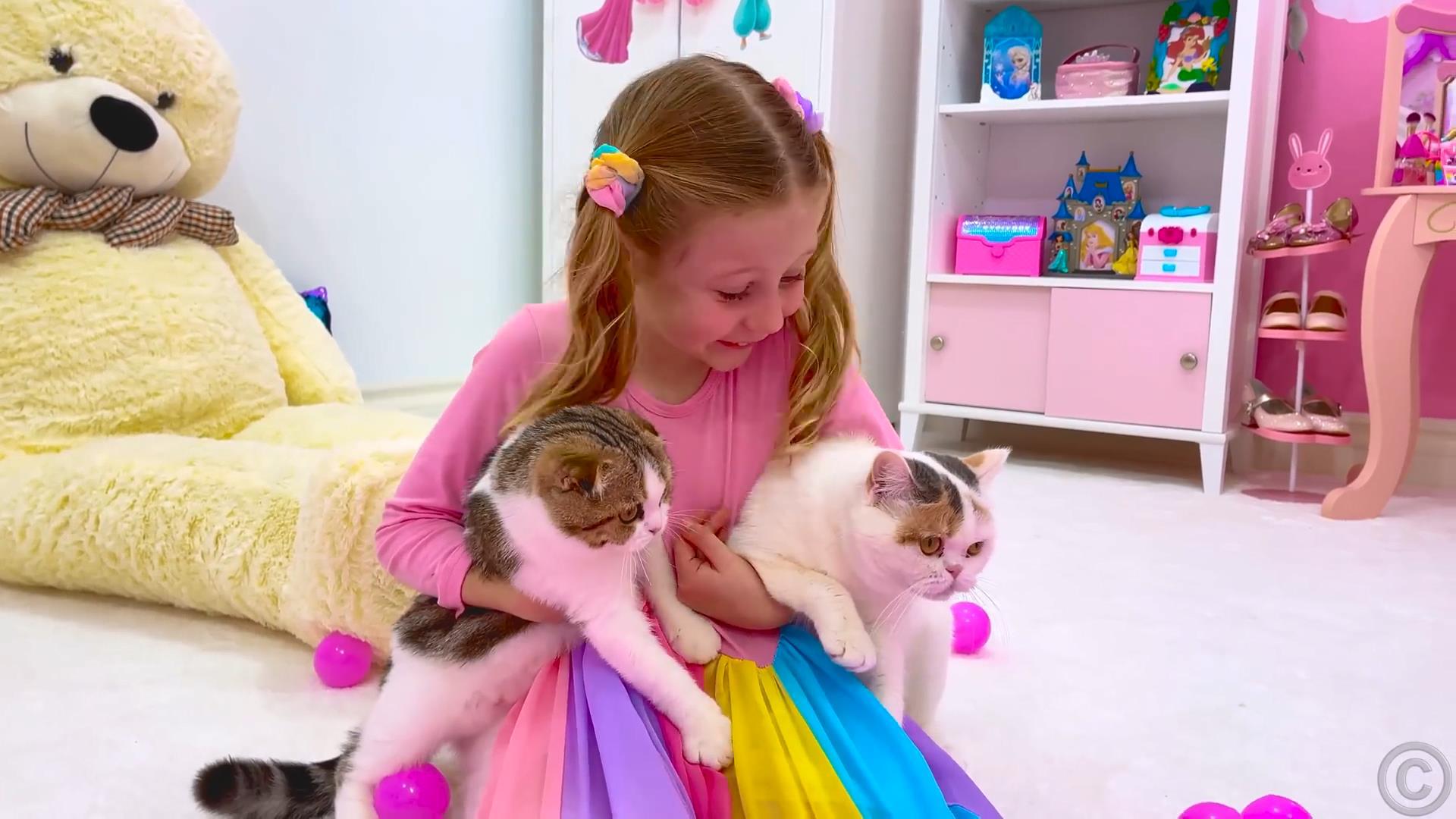 Nastya plays with cats hiding in a tree